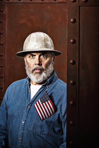 一名男性建筑工人的肖像，口袋里装着一面美国国旗图片下载