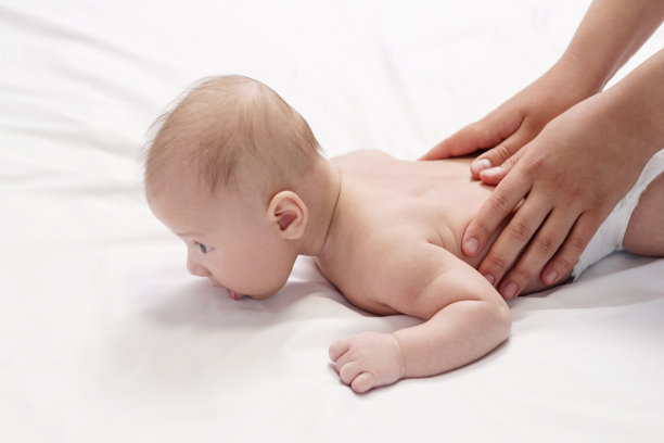 宝宝按摩，特写手放在宝宝背部图片下载