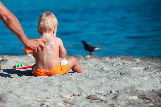男性手涂防晒霜的宝宝回来了。图片下载