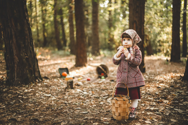 万圣节的概念在森林，小女孩在红外套和围巾笑图片下载
