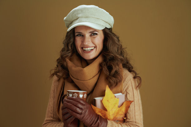 微笑的家庭主妇在米色背景的毛衣图片下载