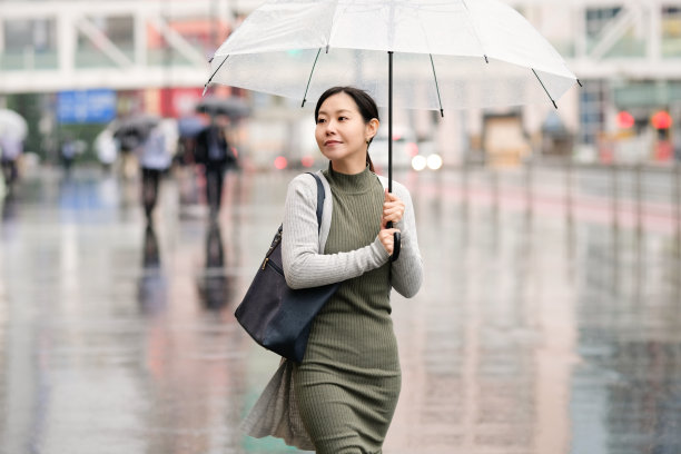 亚洲女商人在雨天通勤图片下载