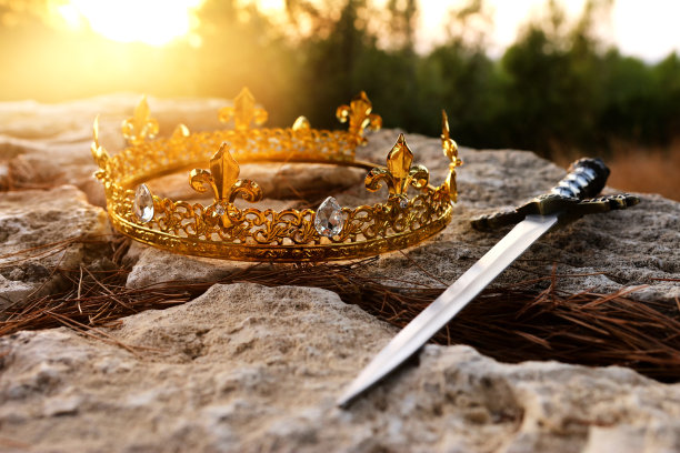 神秘而神奇的照片，金王冠和剑在英国的森林石头。中世纪的概念。图片下载