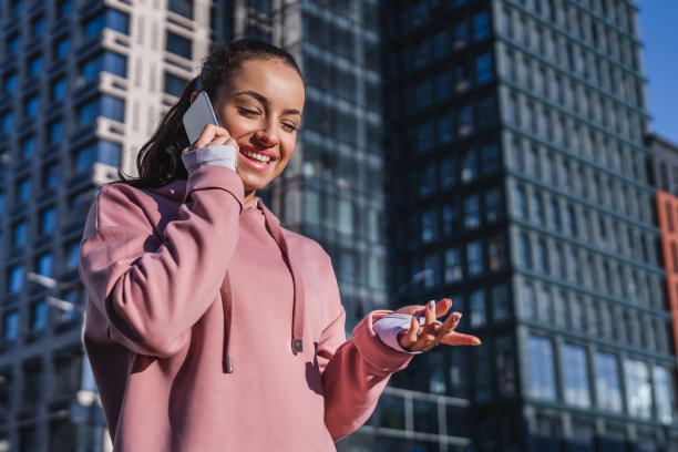 女性运动员在一个大城市打电话的特写照片图片下载