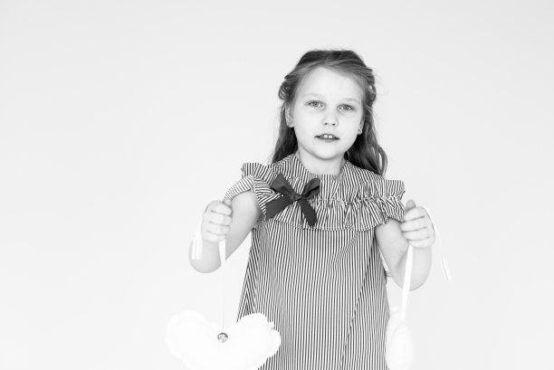 一张黑白照片，一个女孩抱着毛绒玩具。图片下载