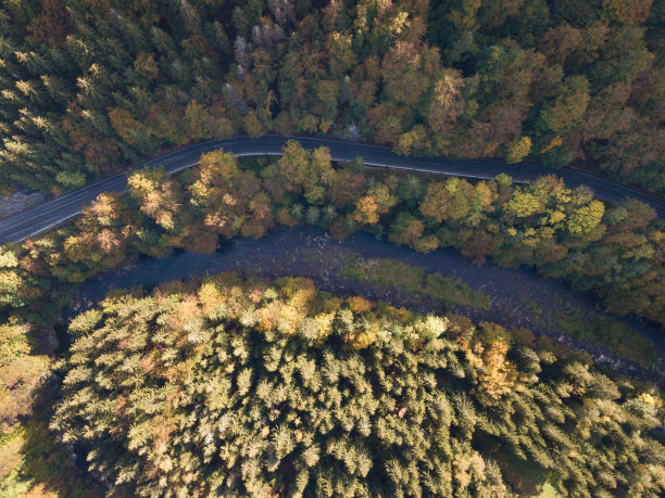 鸟瞰秋天的森林和小溪。沿河而行，山上覆盖着绿色和五颜六色的森林，俯视图。阳光明媚的一天。从空中拍摄的照片。图片下载