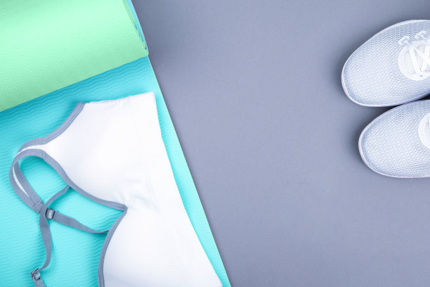 顶视图的白色运动鞋(运动鞋)蓝色绿色瑜伽垫，运动胸罩顶部在柔和的灰色背景。瑜伽普拉提或健身练习图片下载