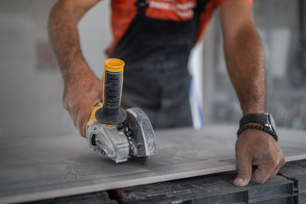 瓷砖。铺砖工将墙面瓷砖贴在粘合剂上，贴有瓷砖找平系统库存照片图片下载