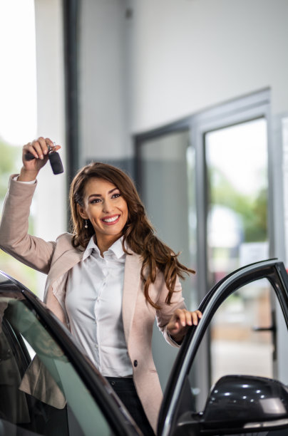 美丽的女人购买汽车在展厅库存照片图片下载