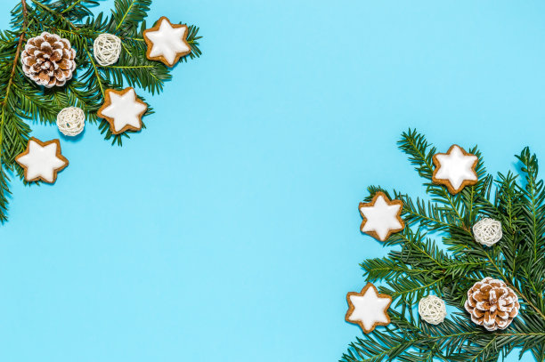 圣诞公寓陈设着有机节日装饰:针叶树的树枝，松果和肉桂星饼干在蓝色的背景。带有副本空间的贺卡。圣诞快乐，恭贺新禧图片下载