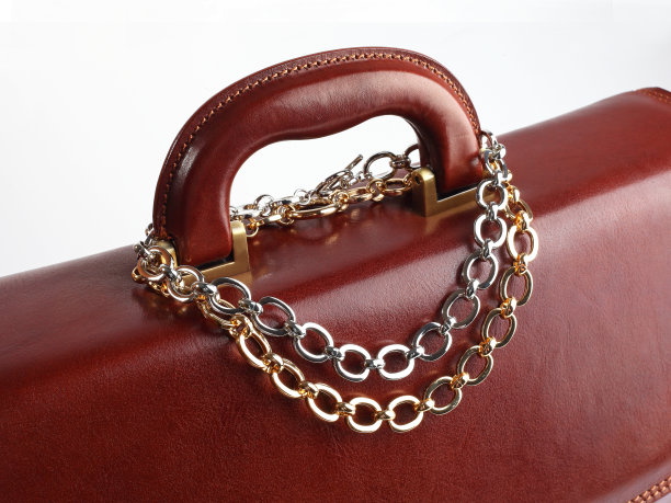 两串项链在男棕色皮箱上图片下载