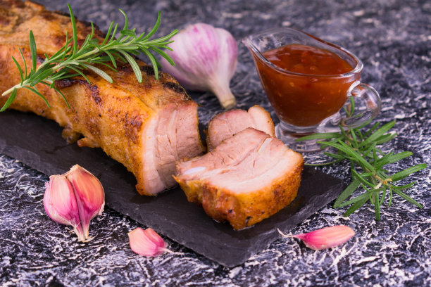 烤排骨配蒜、迷迭香和烧烤酱。图片下载