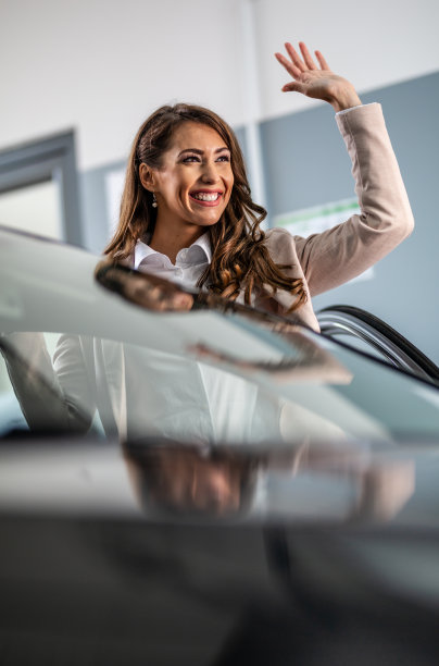 美丽的女人购买汽车在展厅库存照片图片下载