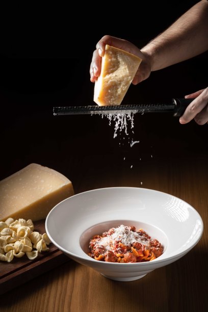 最后一道菜是新鲜手工制作的意大利面，配上番茄酱和帕尔马干酪薄片图片下载