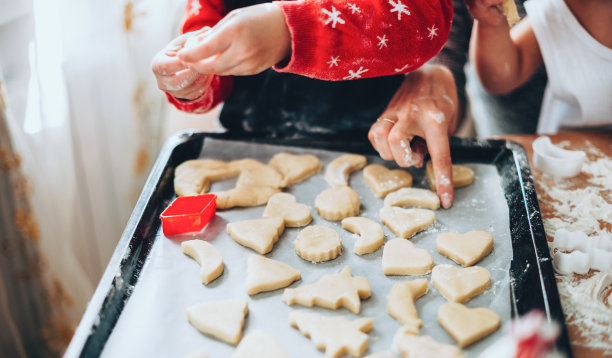 一个白人家庭在节日服装制作不同形式的圣诞蛋糕的特写照片图片下载