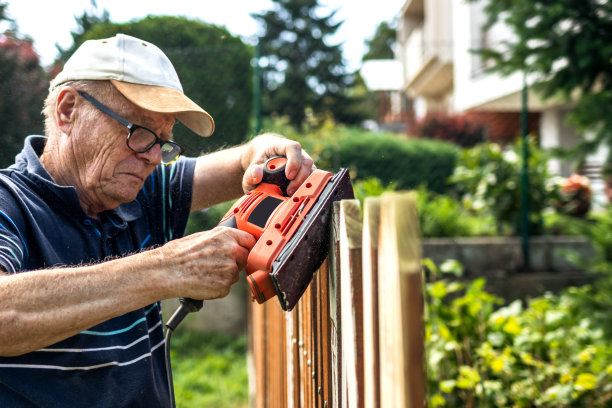 正在修理旧尖桩篱笆的活跃的老人图片下载