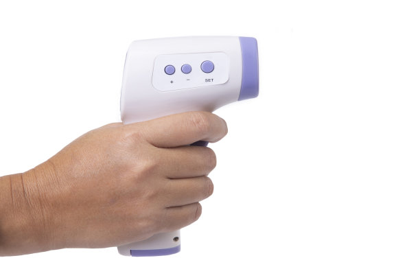 手持白色背景上的小型掌上数字红外温度计。图片下载