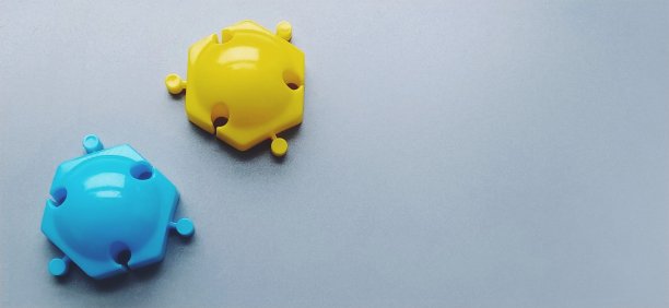 多颜色的细节从儿童设计师的灰色背景。黄色和蓝色的塑料圆盘用于发展手指的精细运动技能。图片下载