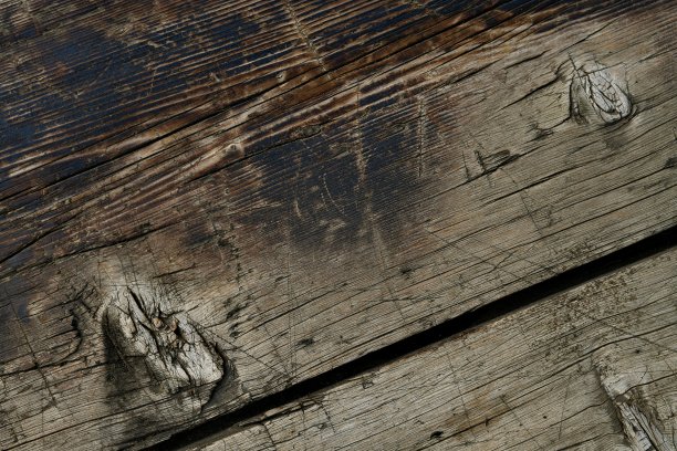 两个旧的宽板的对角木制背景，有许多瑕疵和裂缝，与一个大的强调。图片下载