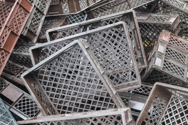 近处是一堆用过的灰色塑料货物包装板条箱的背景。图片下载