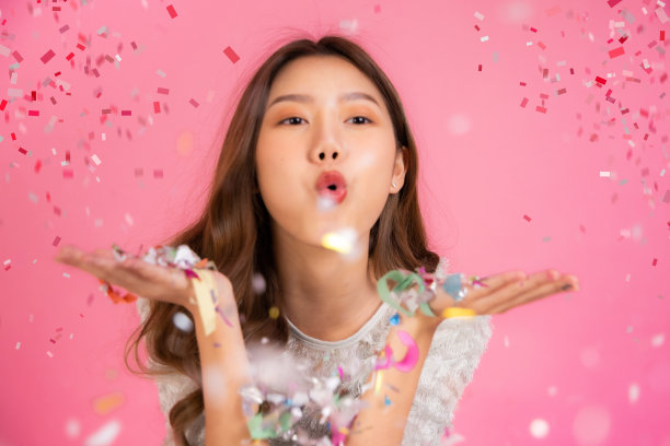 两个可爱的亚洲女人的肖像在圣诞节帽子看孤立的相机在粉红色的背景。迷人的亚洲女人微笑在圣诞节，新年，情人节，生日庆祝概念。图片下载