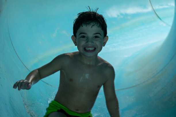 6岁男孩微笑着滑下雪橇，正面照片。图片下载