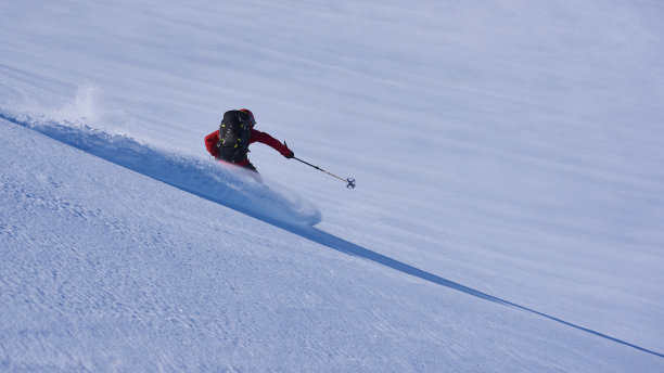 乡村滑雪者在粉状雪中滑雪。图片下载