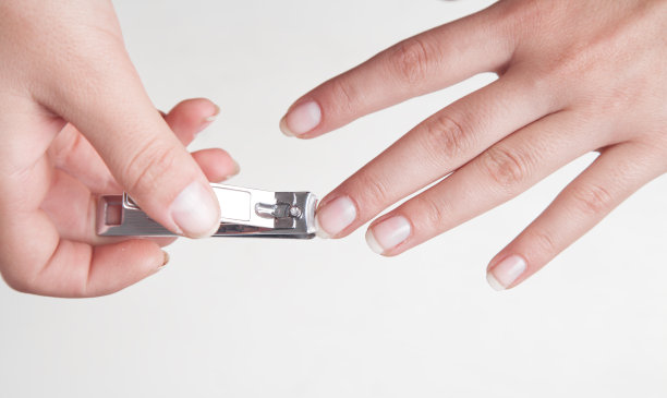 用指甲钳剪指甲的女孩。图片下载