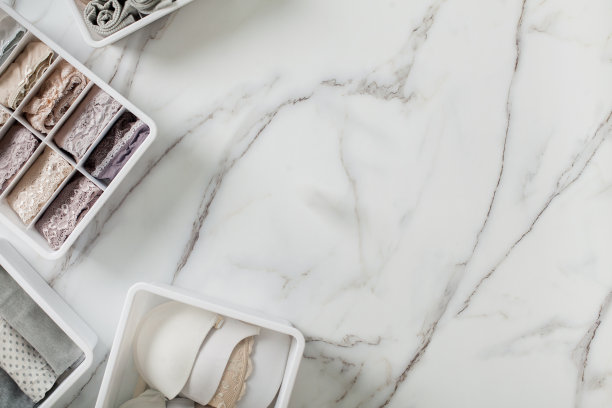 折叠整齐的内衣放在白色大理石背景的抽屉隔板里图片下载