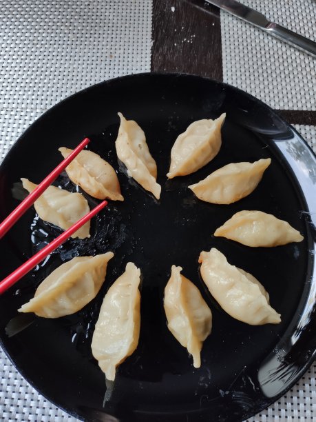 饺子上放着一盘黑色的日本菜图片下载