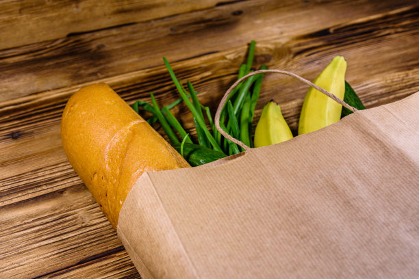 木桌上放着从食品店买来的各种食物。超市购物的概念图片下载