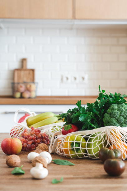 水果和蔬菜在棉花可重复使用的网眼袋木桌在现代明亮的厨房。可持续生活方式的概念图片下载