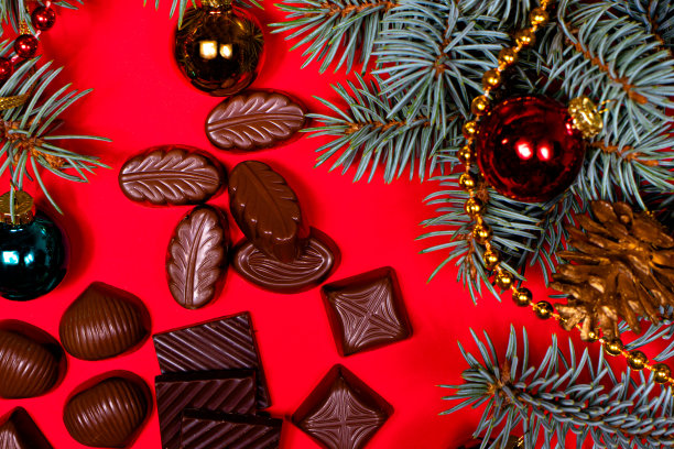 红色背景上的巧克力。新年装饰和巧克力，糖果-节日照片糖果。图片下载