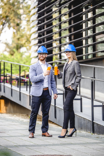 两个生意上的同事在户外喝着橙汁休息图片下载