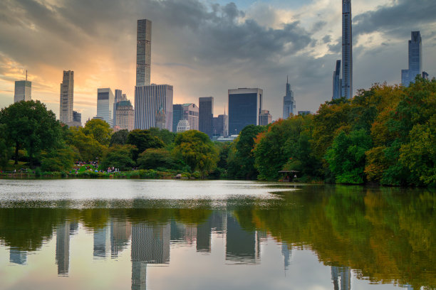 倒影在中央公园的湖水中，背景是树木和摩天大楼图片下载