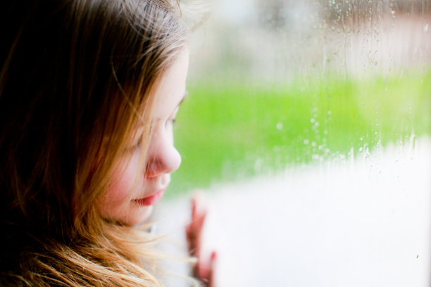 悲伤的小女孩望着窗外图片下载