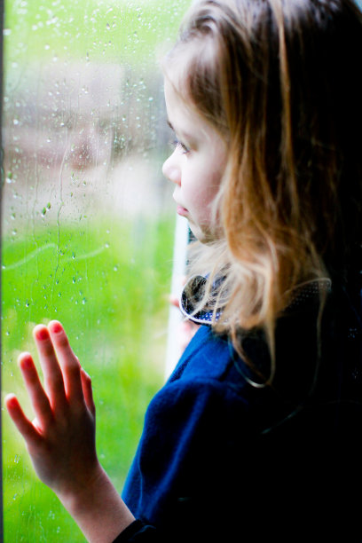 悲伤的小女孩望着窗外图片下载