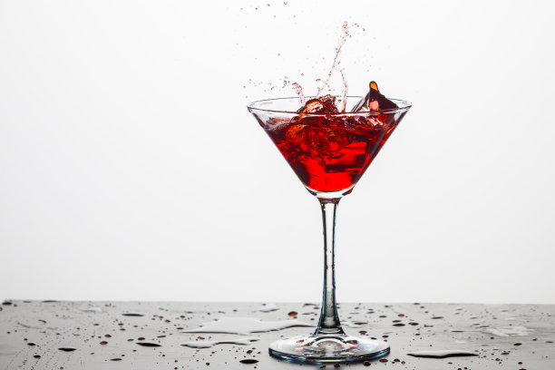 行动摄影。白色背景下的红酒杯。垂直的图像图片下载