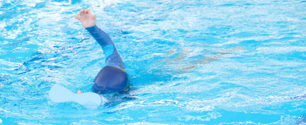 亚洲可爱的男孩穿着泳衣和护目镜用泡沫在游泳池里练习游泳。健康的孩子享受积极的生活方式。暑假锻炼身体，让人耳目一新，身心放松图片下载