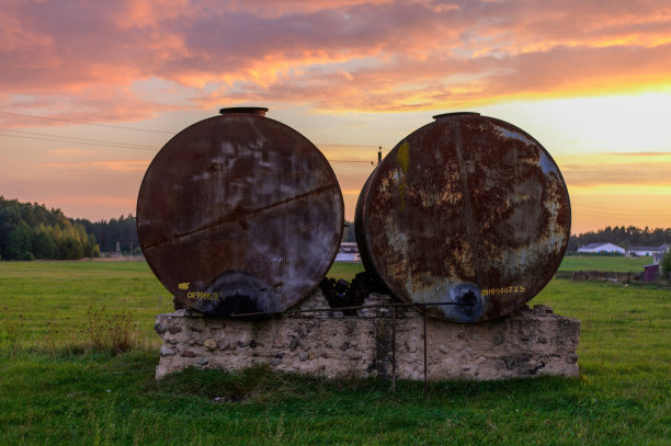 这张照片是秋天里被废弃的生锈集装箱的橙色夕阳，背景是戏剧性的天空图片下载