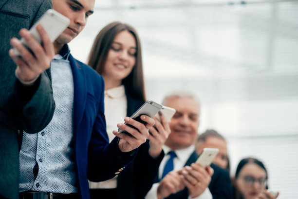 一群微笑着看智能手机屏幕的商务人士图片下载