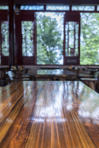 在中国传统茶馆的窗户旁边有木桌，外面有很多树图片下载