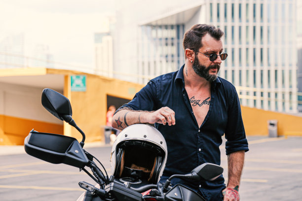 时髦的男人在他的摩托车上摆姿势图片下载