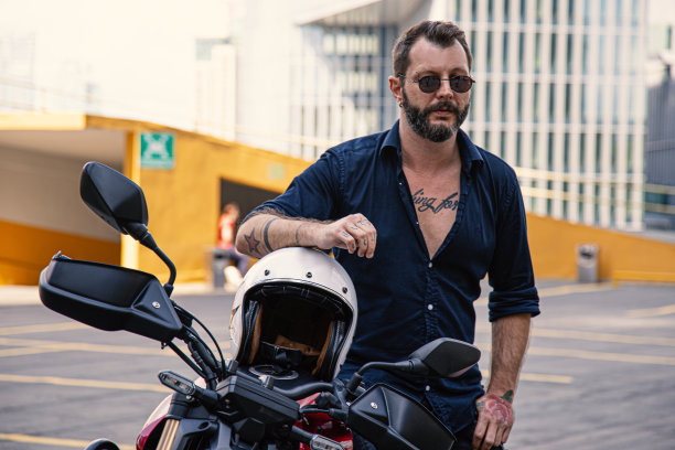 时髦的男人在他的摩托车上摆姿势图片下载