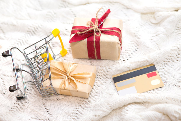 盒子与礼物在圣诞节包装在购物车上白色针织毯子。黑色星期五，买新年礼物。图片下载