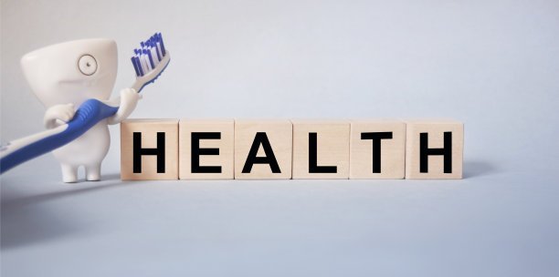 在浅蓝色背景的木方上刻有健康字样，以及与口腔医学相关的铭文。健康医学理念。图片下载