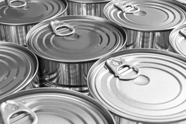 近距离的照片，铝罐的背景与开瓶器。黑色和白色的铝罐。铝饮料罐顶视图。可以喝。用于包装饮料的金属容器。图片下载