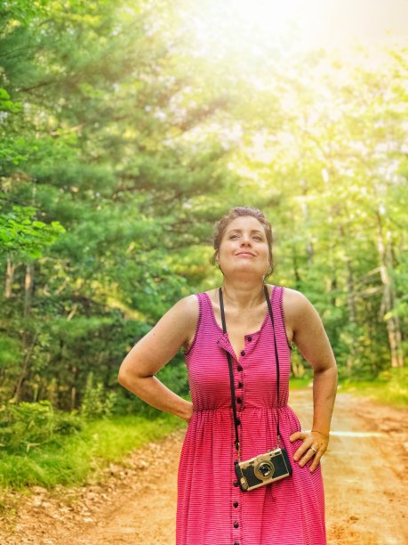 骄傲和快乐的中年妇女拍照和享受自然散步在阳光下图片下载