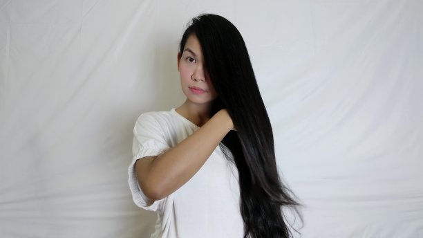 亚洲漂亮的女人与美丽的直长发在白色的背景图片下载