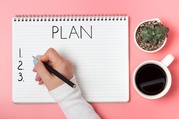 女性手写在粉红色背景的记事本上书写，俯视图图片下载